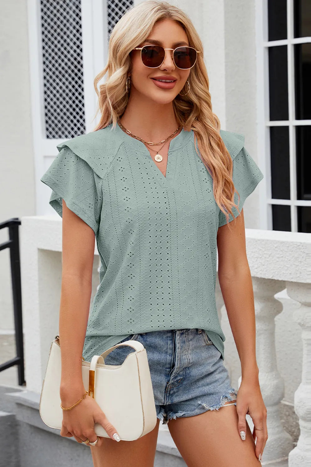 Light blue eyelet notched flutter sleeve T-shirt from Trendsi, featuring a relaxed fit and decorative flutter sleeves.