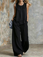 Women's sleeveless two-piece set with solid color wide-leg pants and matching top, stylish ensemble by Plush Fashion Hub.