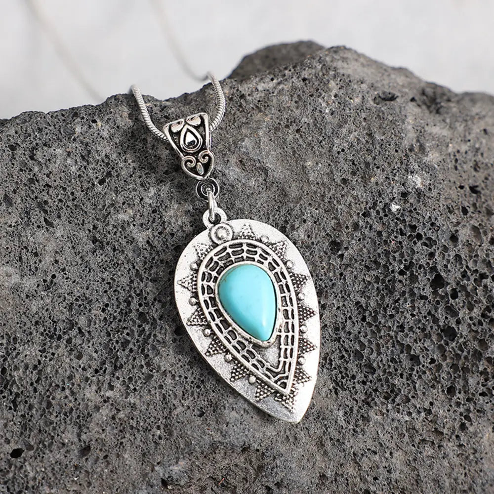 Geometric alloy pendant necklace featuring modern, angular shapes, worn on a model's neckline, by Plush Fashion Hub.