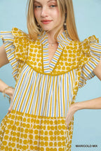 Umgee Mix Patchwork Flutter Sleeve Tiered Dress featuring colorful patchwork fabric and flowing tiered skirt on a model.