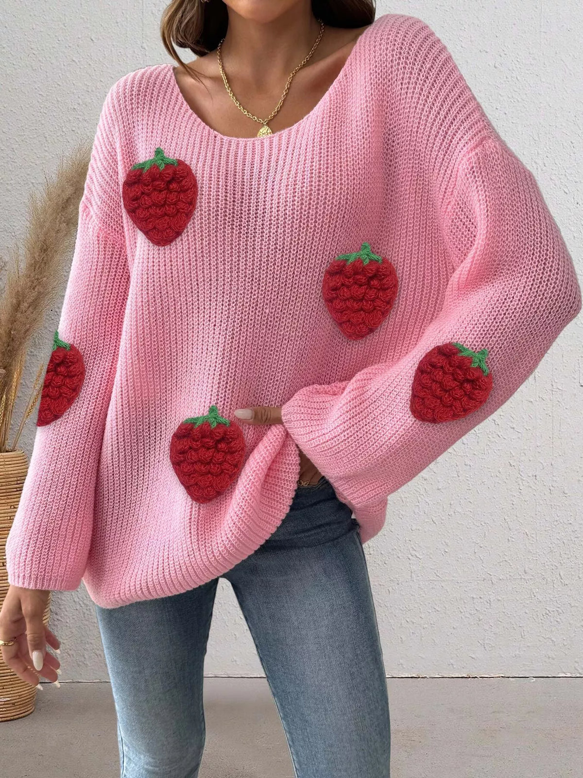 Oversized strawberry applique sweater from Trendsi, featuring a cozy knit design with colorful strawberry patches.