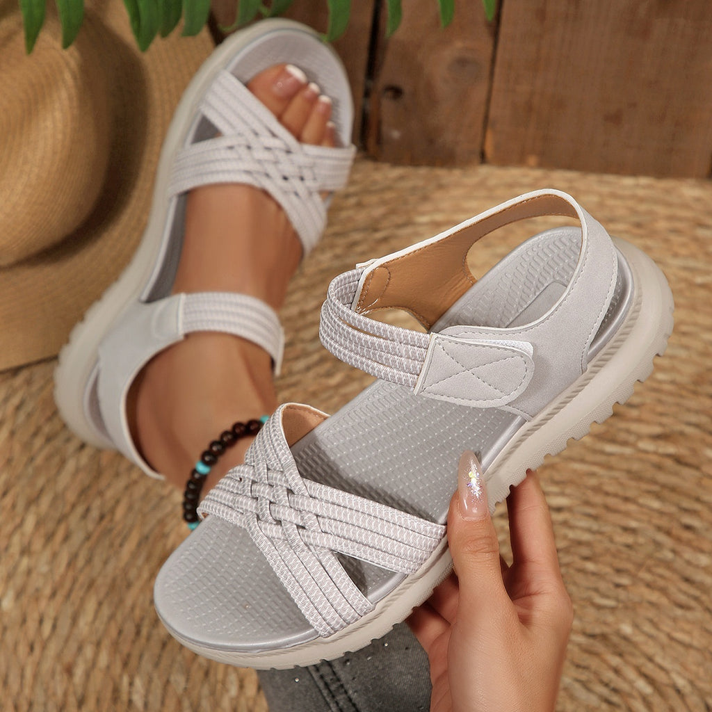 Women's open toe woven strap flat sandals with faux leather slides, featuring comfortable design and stylish straps.