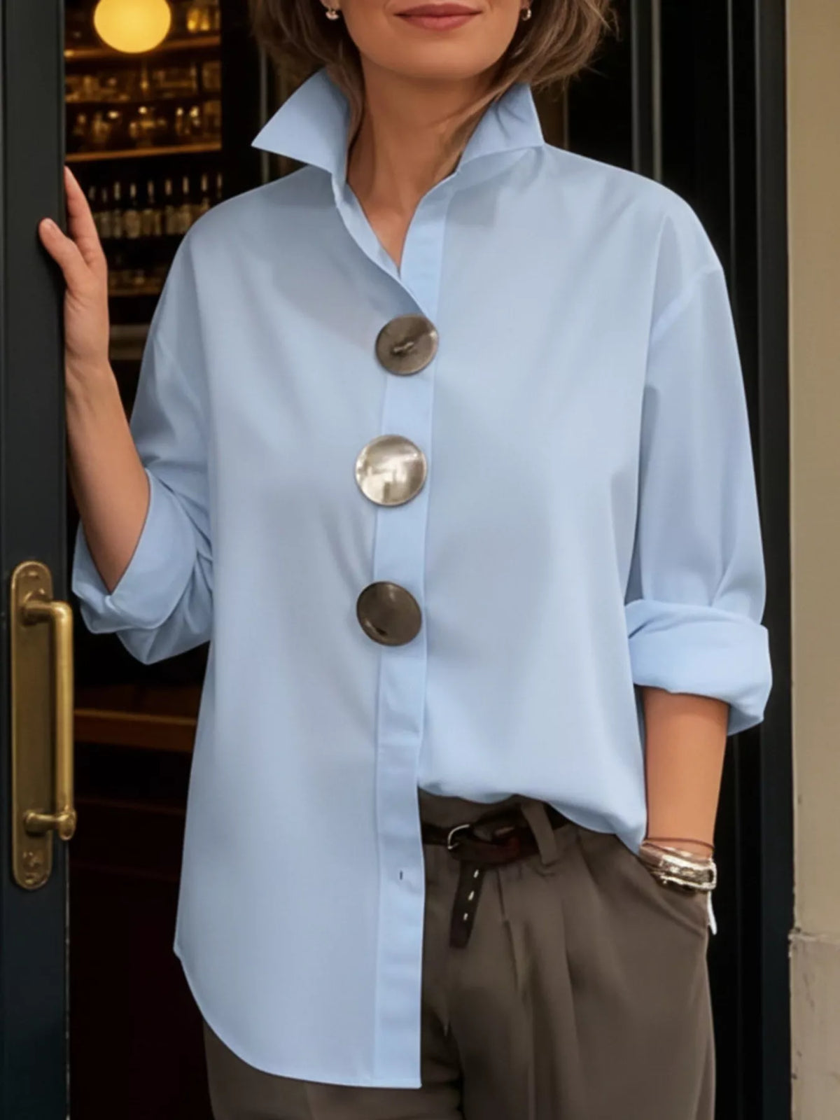 Full size oversized metal button long sleeve shirt by Trendsi, plus size, with a relaxed fit and metallic button details.