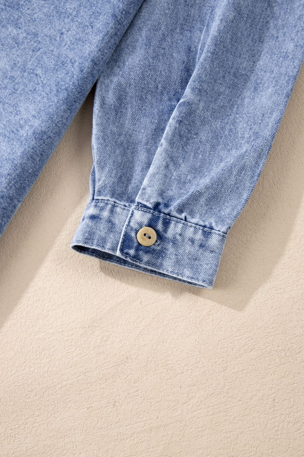 VYSN Raw Hem Button Down Long Sleeve Denim Dress displayed on a hanger, showcasing its casual style and raw hem detail.