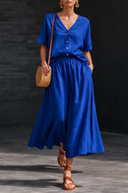 Women's V-neck button-up top and long skirt set by Plush Fashion Hub, casualwear with a relaxed fit and stylish design.