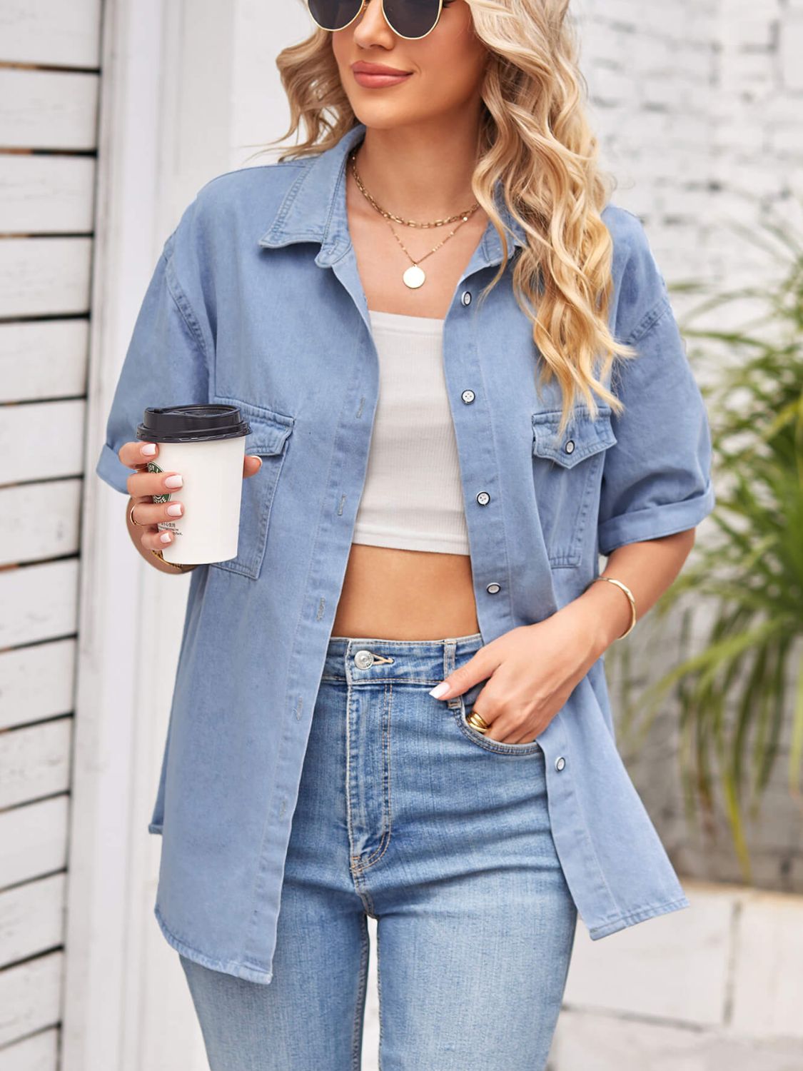 Denim short sleeve collared jacket by Plush Fashion Hub hanging on a clothing rack, showcasing its classic design and denim fabric.