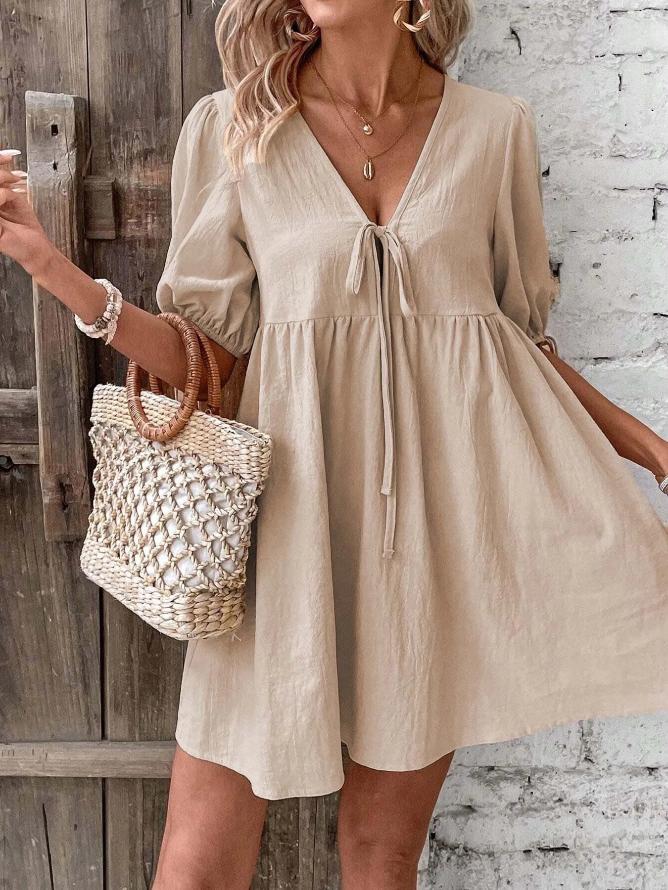 Light blue 100% cotton V-neck tie-front mini dress with puff sleeves, featuring a stylish and breathable design.