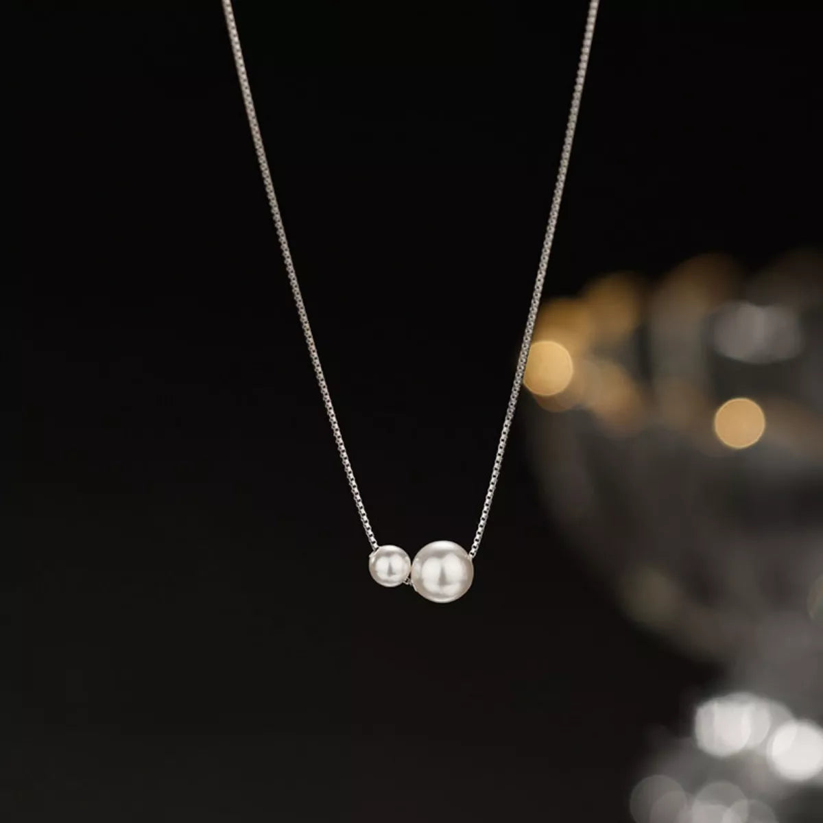 Sterling silver pearl necklace with lustrous white pearls, designed by Shopimist, displayed on a white background.