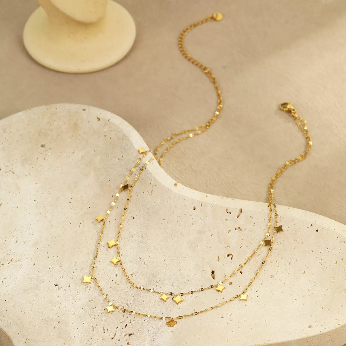 Gold plated layered star charm necklace from Plush Fashion Hub, featuring multiple star pendants on a delicate chain.