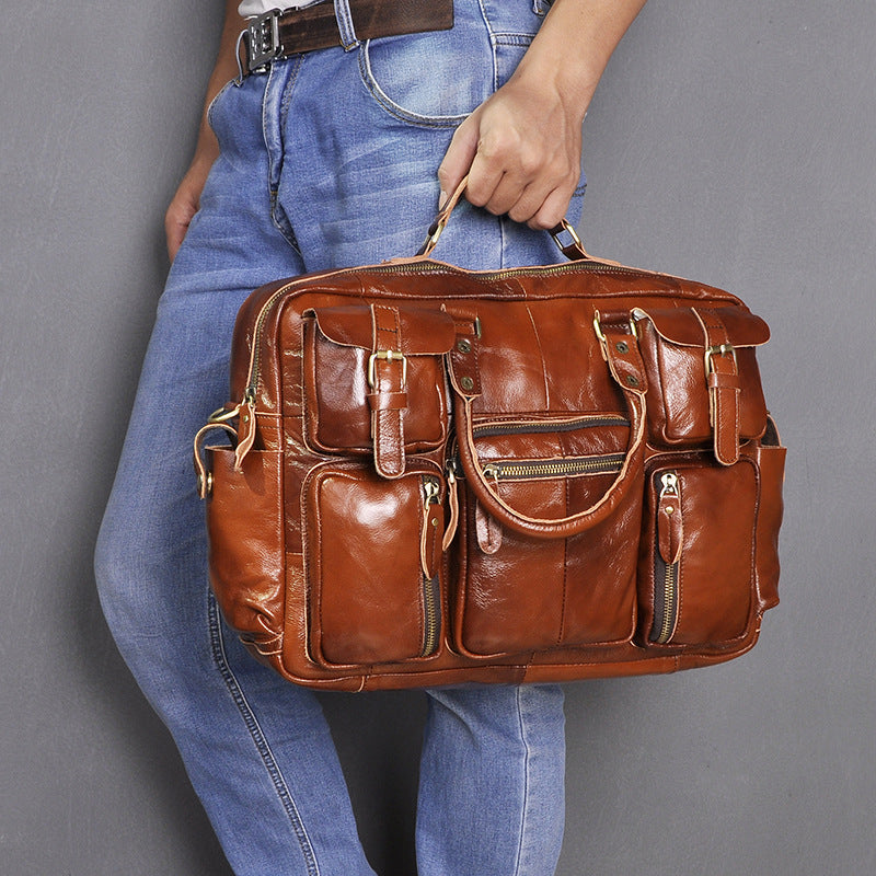 Plush Fashion Hub men's first layer cowhide 16-inch large-capacity briefcase with multiple compartments and sturdy leather handles.