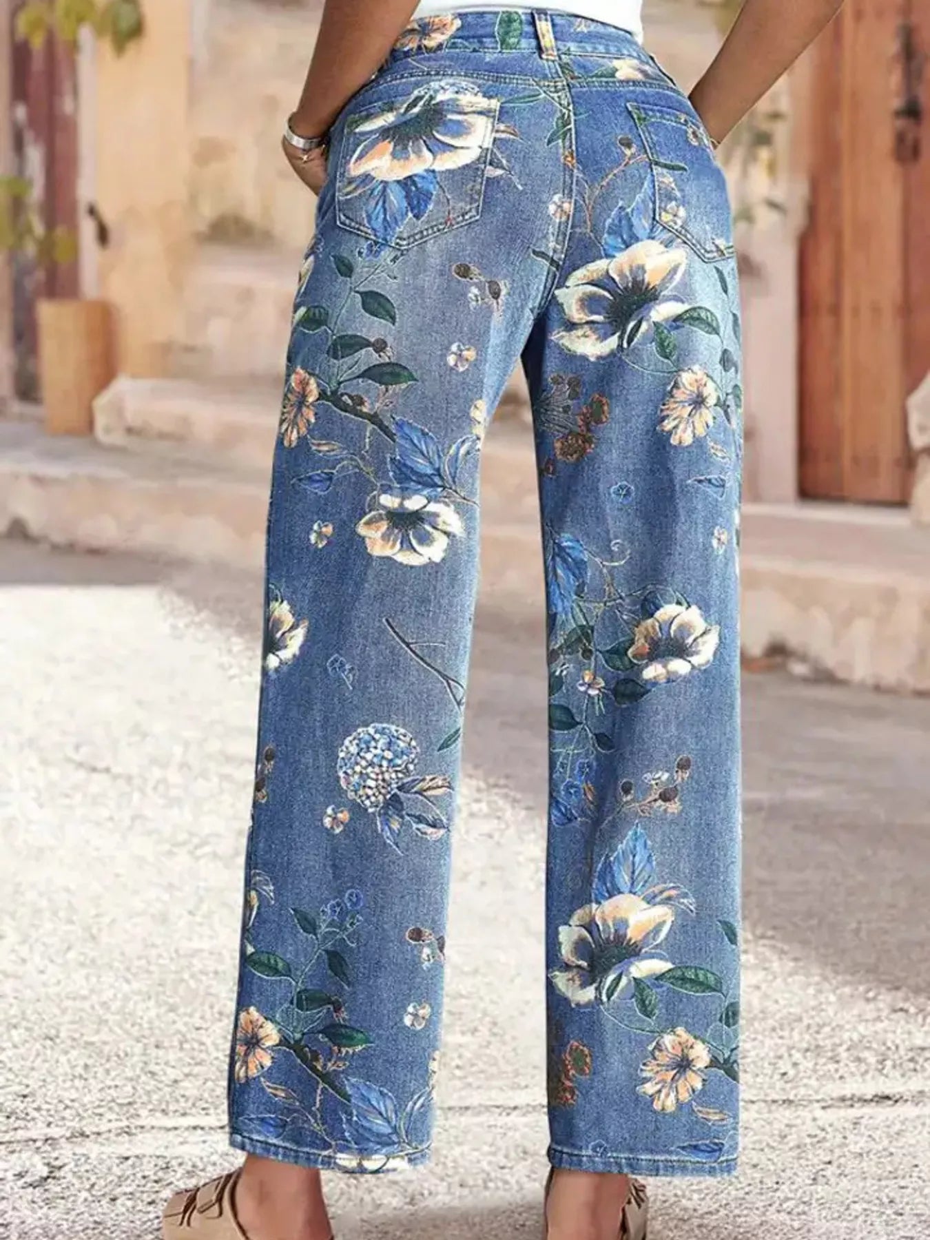 Floral print wide leg jeans by Trendsi featuring a colorful floral pattern and relaxed fit, styled as casual bottoms.