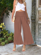 Women's wide-leg smocked waist casual trousers by Trendsi, lightweight and comfortable pants, shown in a relaxed fit and flowy fabric.