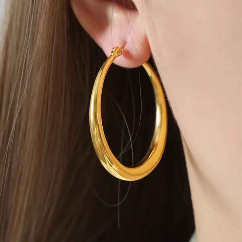 18K gold-plated hoop earrings with a shiny finish, featuring a classic circular design and seamless closure.