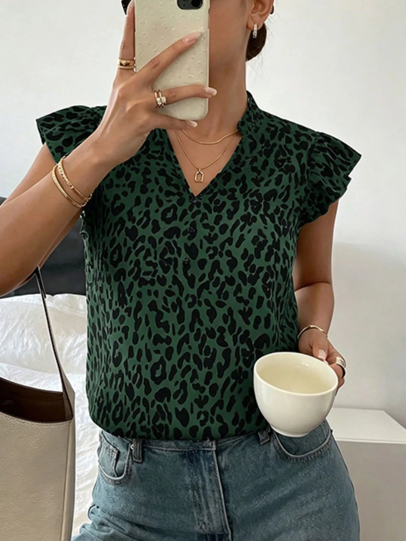 Leopard print ruffle sleeve blouse by Plush Fashion Hub, featuring a stylish design and playful pattern, displayed on a hanger.