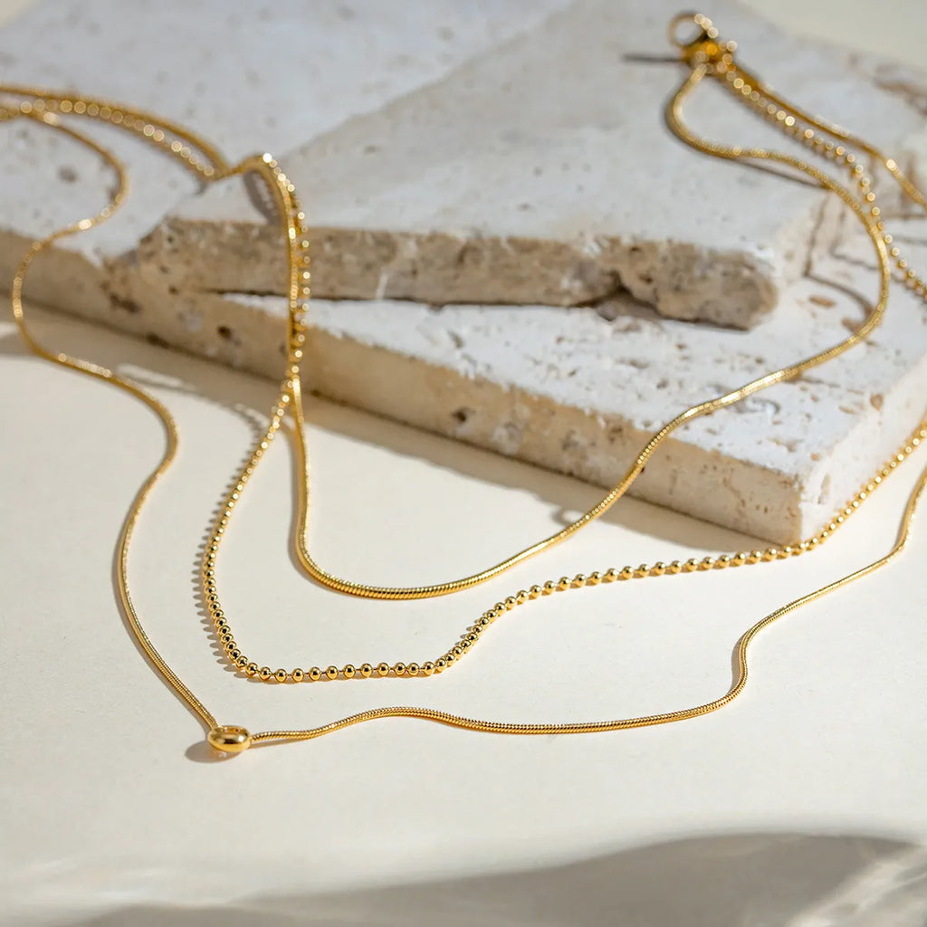 Gold-plated layered necklace with delicate chains and subtle pendant, showcasing elegant design and fine craftsmanship.