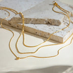 Gold-plated layered necklace with delicate chains and subtle pendant, showcasing elegant design and fine craftsmanship.