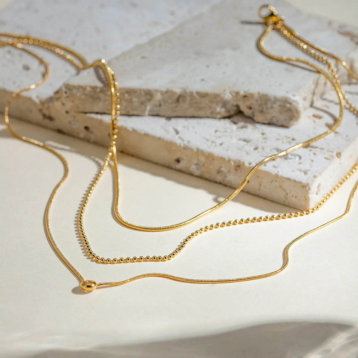 Gold-plated layered necklace with delicate chains and subtle pendant, showcasing elegant design and fine craftsmanship.