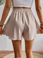 Flowy drawstring waist shorts romper by Trendsi featuring a relaxed fit and lightweight fabric, shown in a natural, casual style.