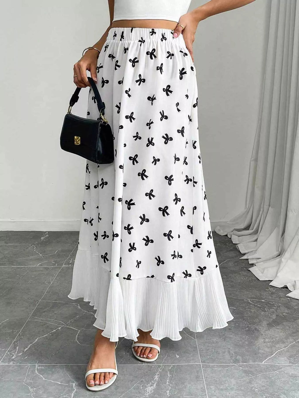 Flowy maxi skirt with bow print and ruffle hem by Trendsi, featuring a lightweight, flowing fabric and stylish design.