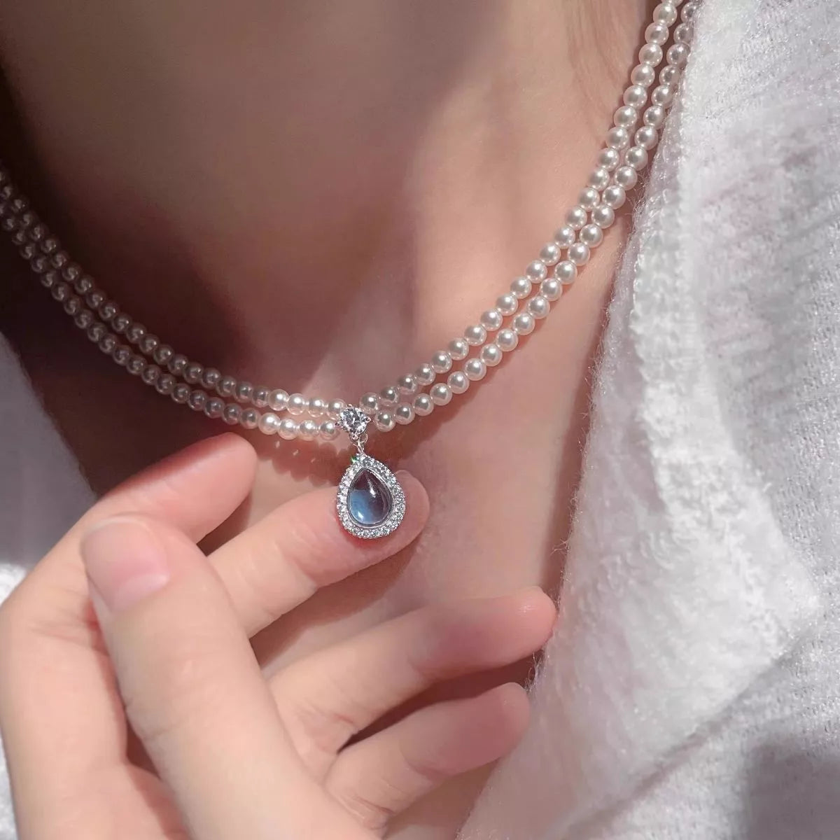 Double layered pearl necklace from Shopimist with a teardrop pendant, featuring elegant pearls on a delicate chain.