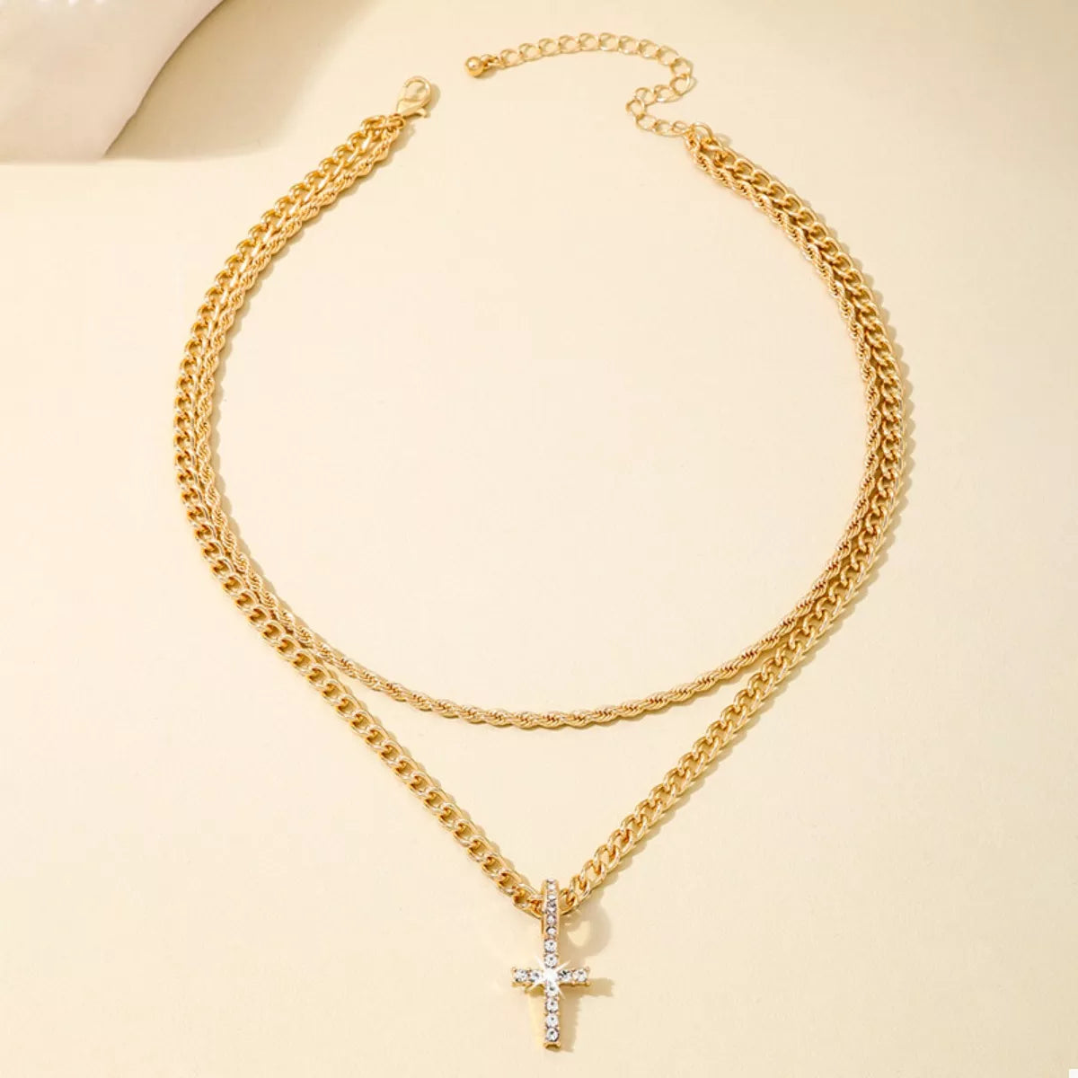 Layered gold chain cross pendant necklace from Plush Fashion Hub, featuring multiple gold chains with a cross pendant, on a white background.