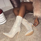 Elegant women’s rhinestone high heel boots with pointed toes, featuring sparkling embellishments and a sleek silhouette.