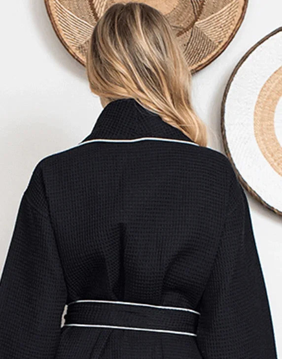Back view of black knee-length waffle robe for women with piping from Plush Fashion Hub, featuring a cozy, textured fabric and a relaxed fit.