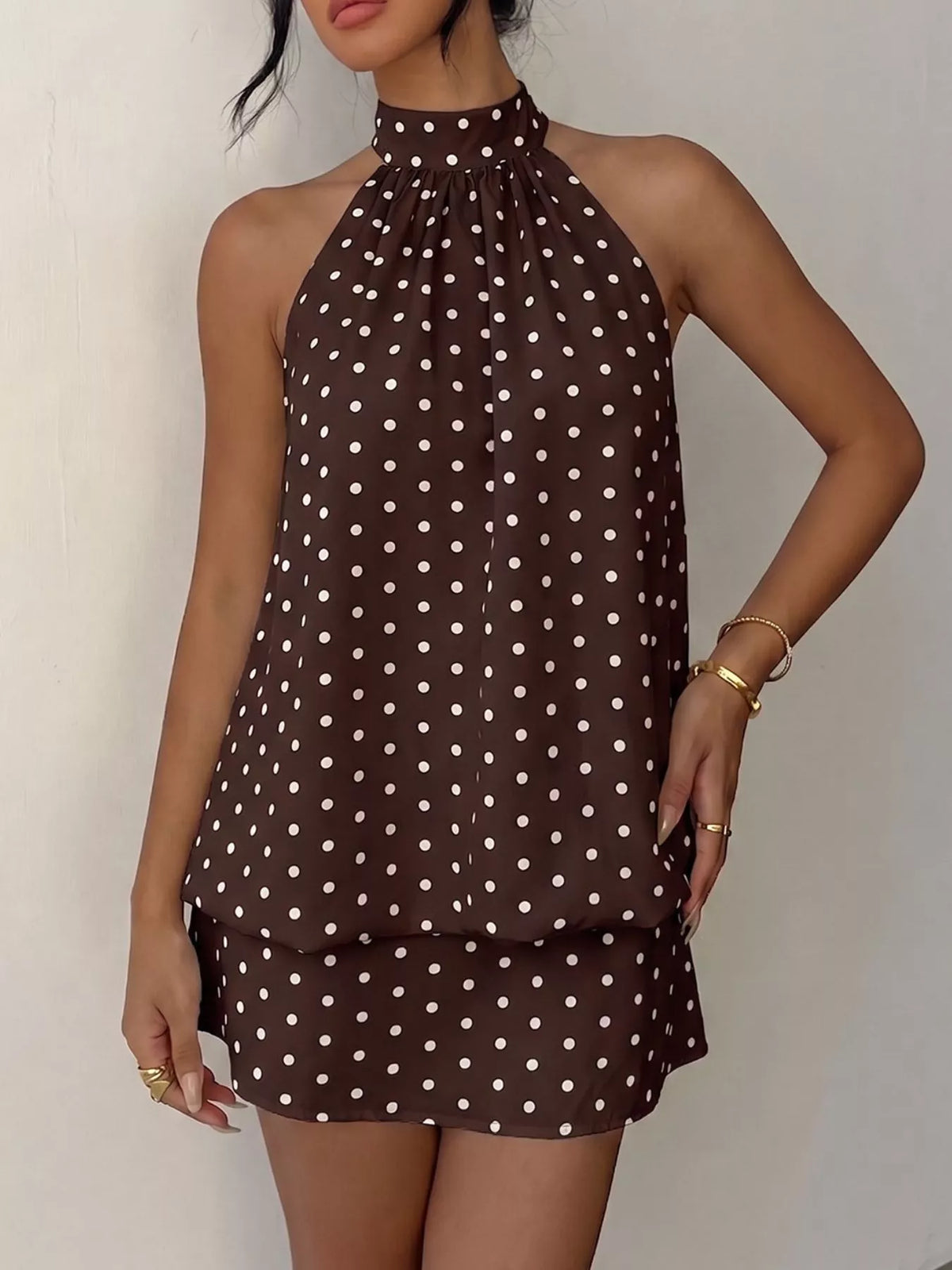Polka dot halter neck mini dress by Plush Fashion Hub featuring a sleeveless design and a fitted silhouette.