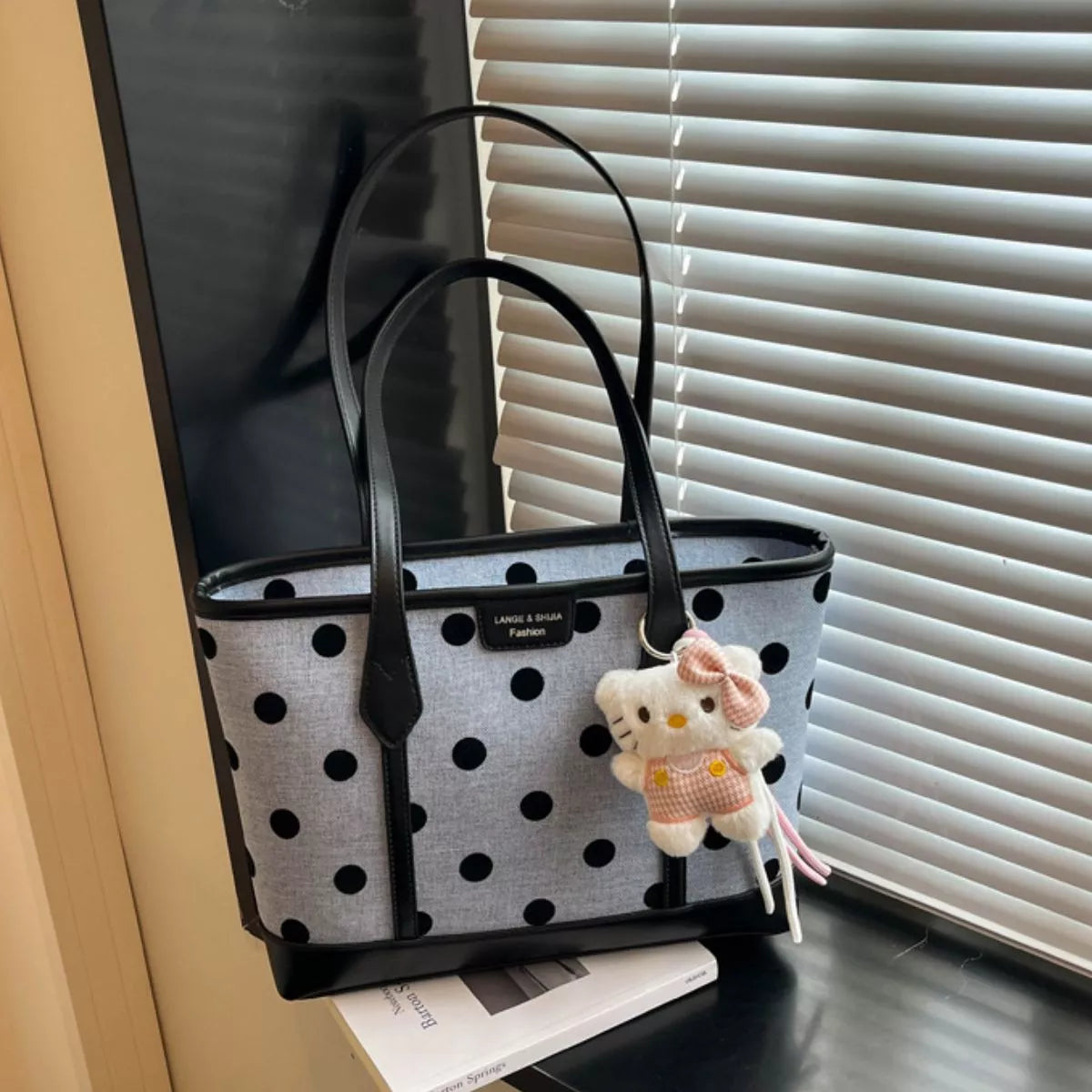 Polka dot shoulder handbag for women by Trendsi, stylish black and white handbag with a shoulder strap and polka dot pattern.