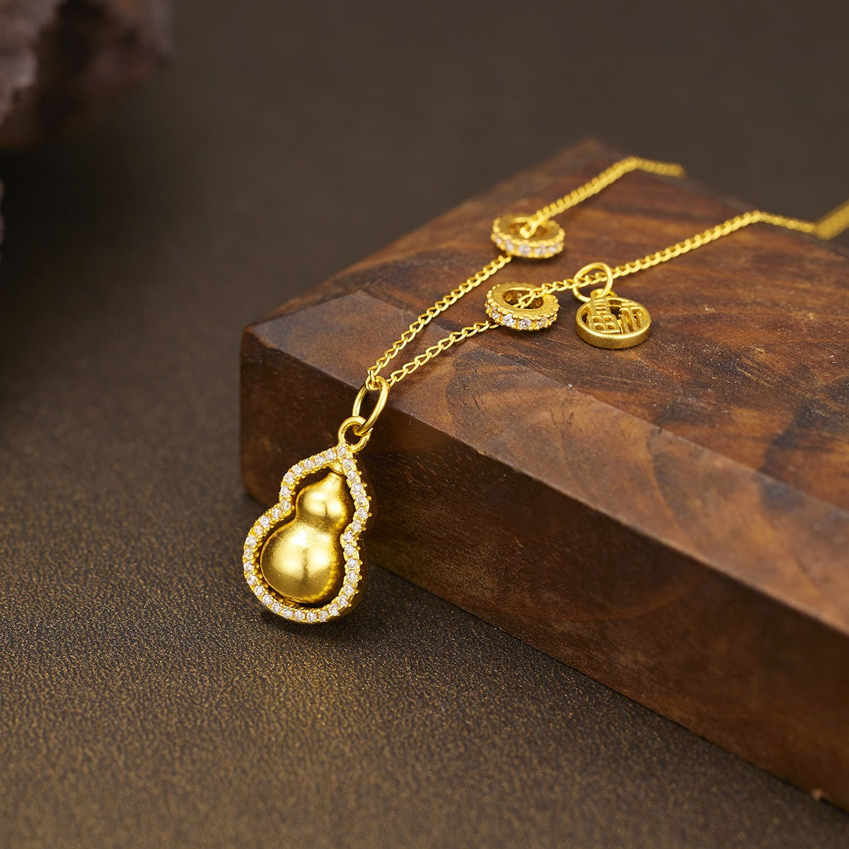 18K gold-plated gourd pendant necklace with intricate design, hanging on a delicate chain, displayed against a neutral background.