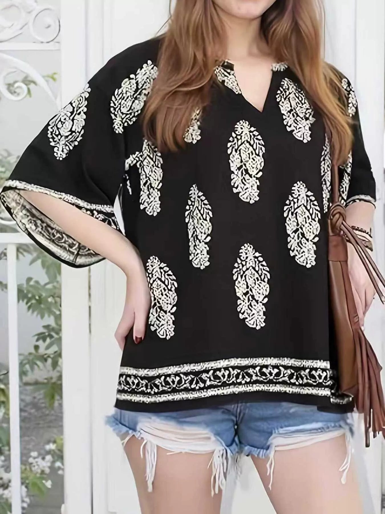 Printed notched 3/4 sleeve blouse by Plush Fashion Hub featuring a stylish design and comfortable fit, shown on a model.