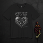 Black T-shirt from Wear Your Worship's SEEN. Her. collection featuring "Beauty Rising Out of Pain" Isaiah 61:3 design, flat lay.