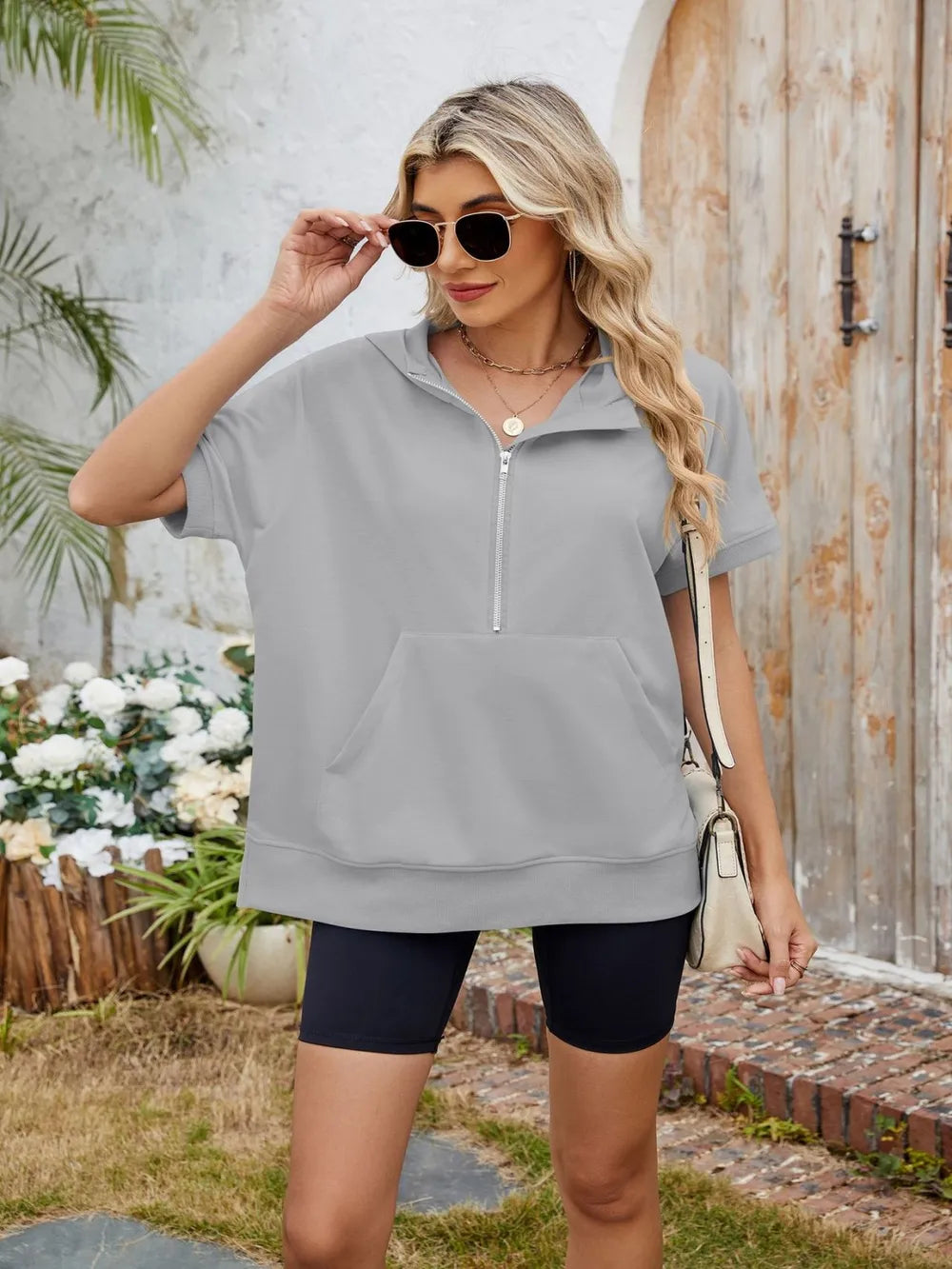Black half zip short sleeve hooded top from Trendsi with a relaxed fit and lightweight fabric, perfect for casual wear.