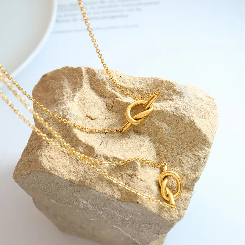 18K gold-plated titanium steel knot necklace with a sleek, polished finish, showcasing a modern jewelry design.