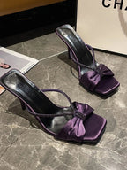 Elegant faux leather mid-heel sandals with bow detail for women, featuring a stylish and comfortable design by Trendsi.