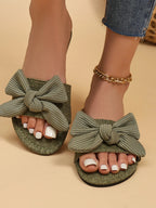 Women's open toe flat sandals with bow accent by Trendsi, featuring comfortable slip-on design for summer wear.