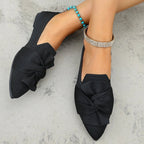 Elegant bow embellished pointed toe flat slip-on shoes by Trendsi, featuring a stylish design and comfortable fit.