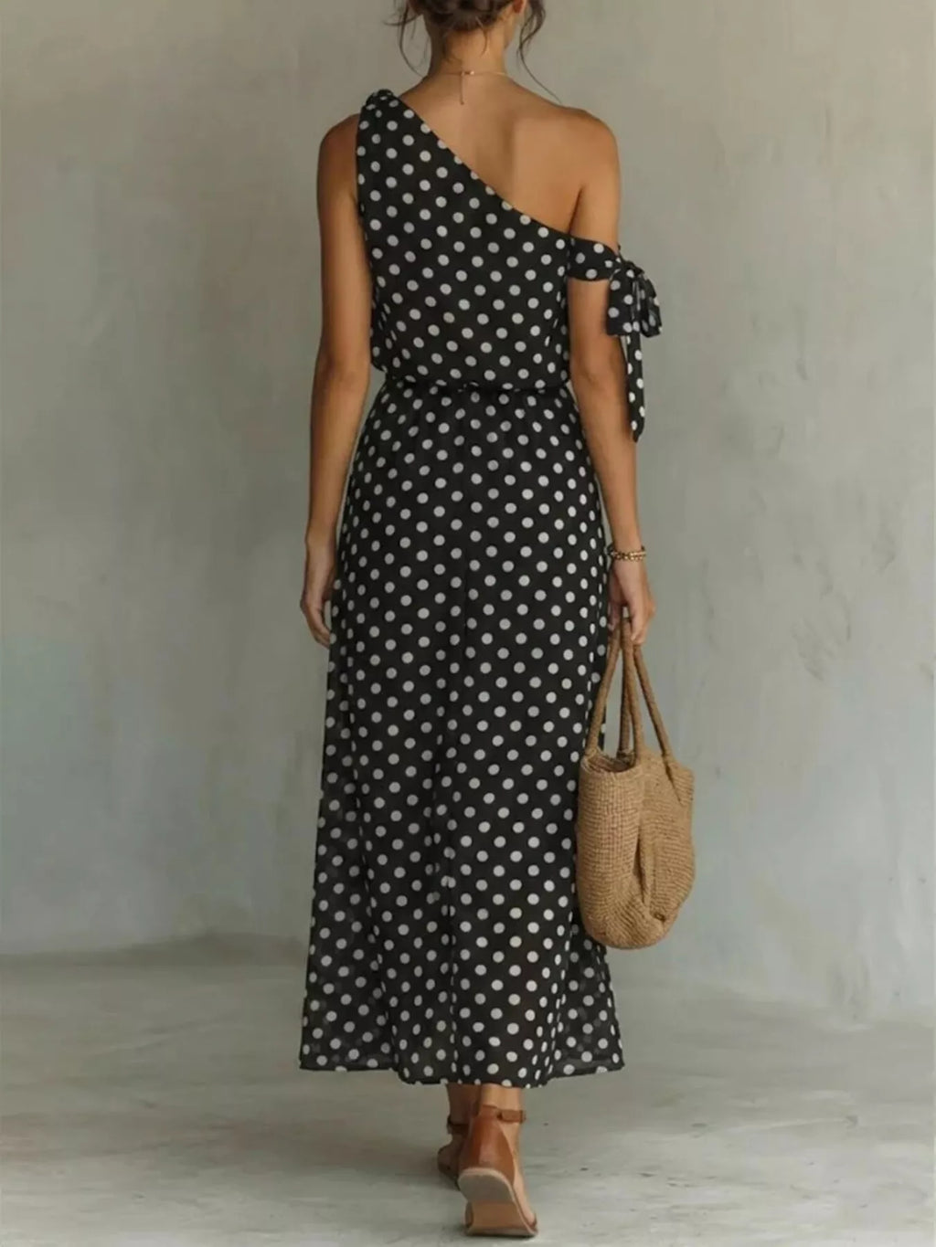 Plus size polka dot one-shoulder maxi dress by Trendsi, featuring a flowing silhouette and stylish design.