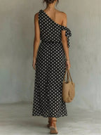 Plus size polka dot one-shoulder maxi dress by Trendsi, featuring a flowing silhouette and stylish design.