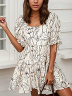 Women's floral print square neck ruffled mini dress by Trendsi, lightweight smocked dress with a feminine floral pattern and ruffle details.