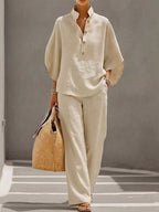 Plus size women's two-piece button-detail 3/4 sleeve top and pants set by Trendsi, shown in a stylish dress format.