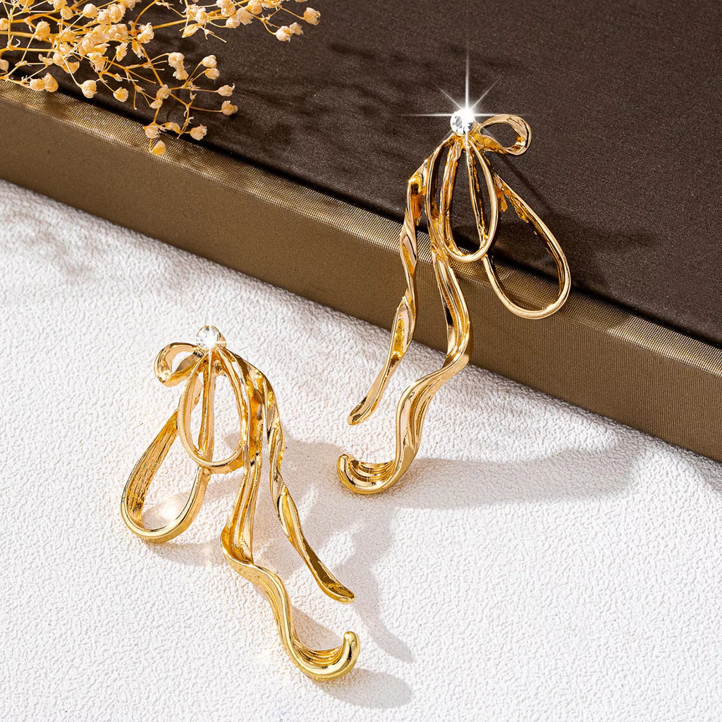 18K gold-plated bow earrings with delicate design, featuring shiny gold finish and elegant style for women.
