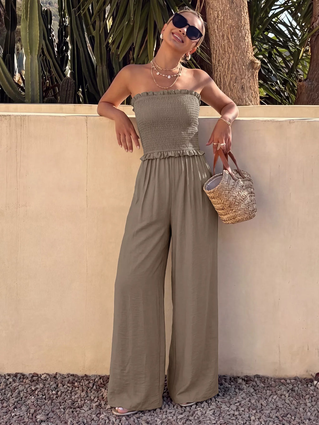 Smocked strapless wide-leg jumpsuit by Plush Fashion Hub with relaxed fit and stylish design, shown hanging on a hanger.