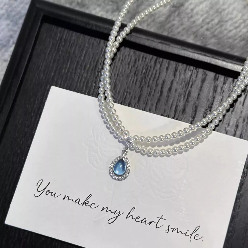 Double layered pearl necklace with teardrop pendant from Shopimist, featuring lustrous pearls and an elegant teardrop charm.