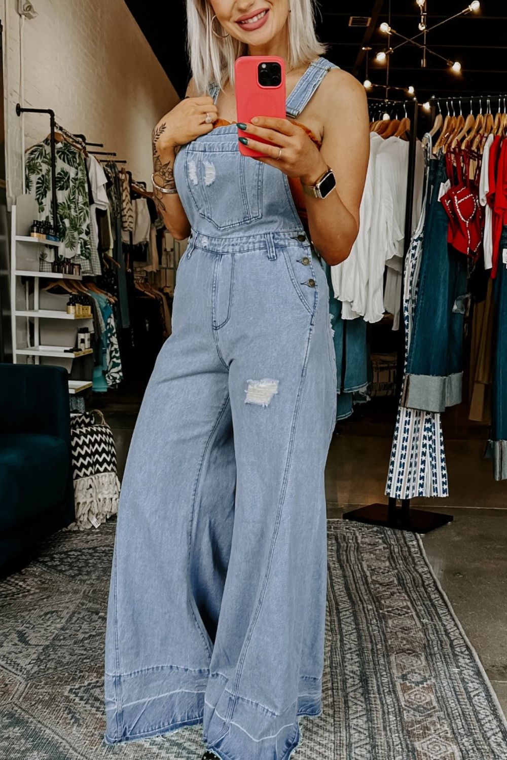 Women's distressed wide leg denim overalls with casual relaxed fit, featuring distressed details and adjustable shoulder straps.