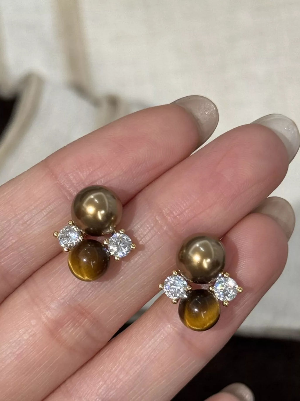 Tiger Eye stud earrings with gold-tone settings, featuring polished, round gemstone beads, perfect for elegant jewelry accents.