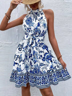 Printed sleeveless tie waist dress by Shopimist featuring a flowy fabric and stylish design, perfect for warm weather.