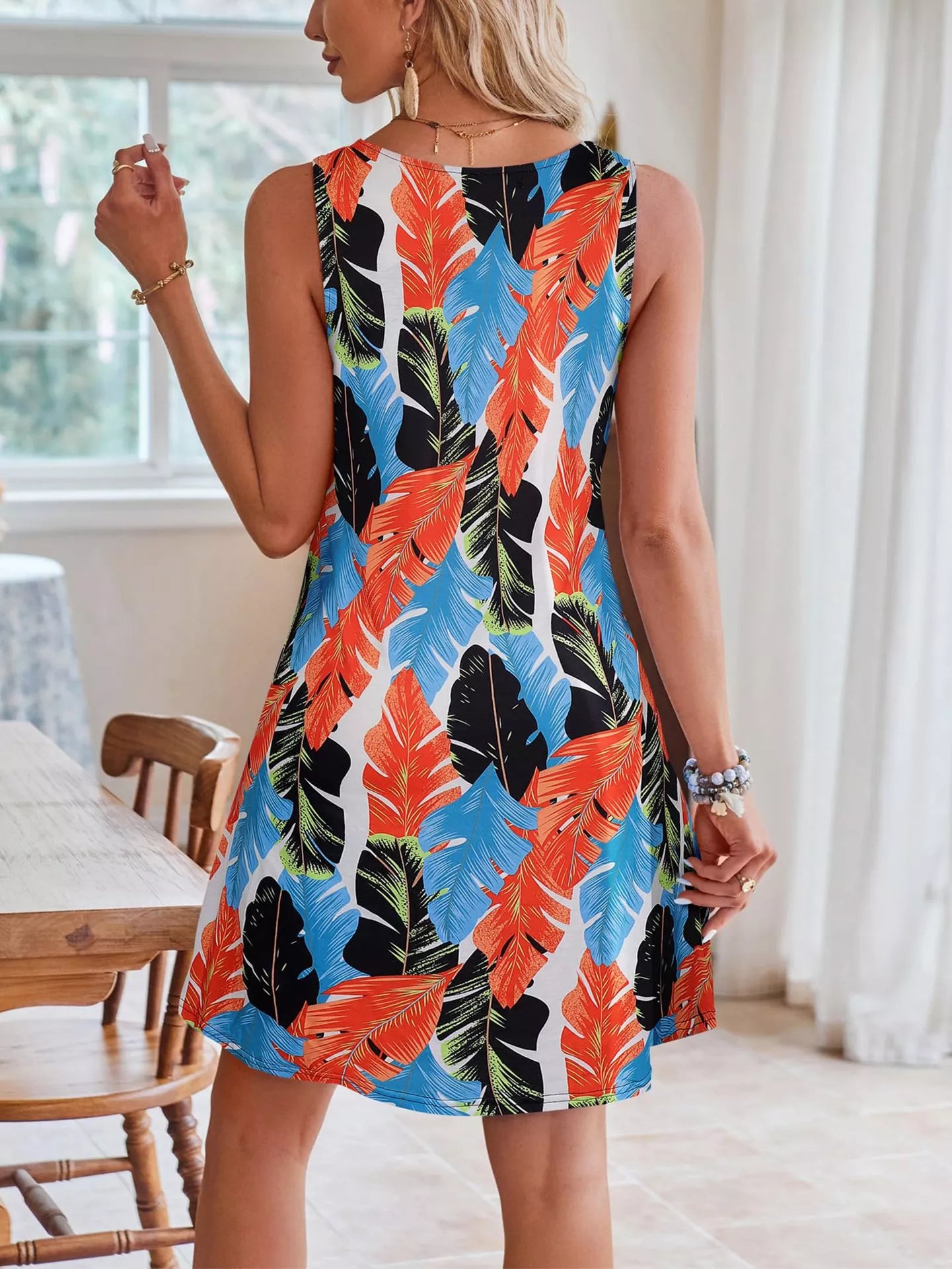 Tropical leaf print V-neck sleeveless dress by Shopimist hanging on a hanger with vibrant green and yellow foliage design.