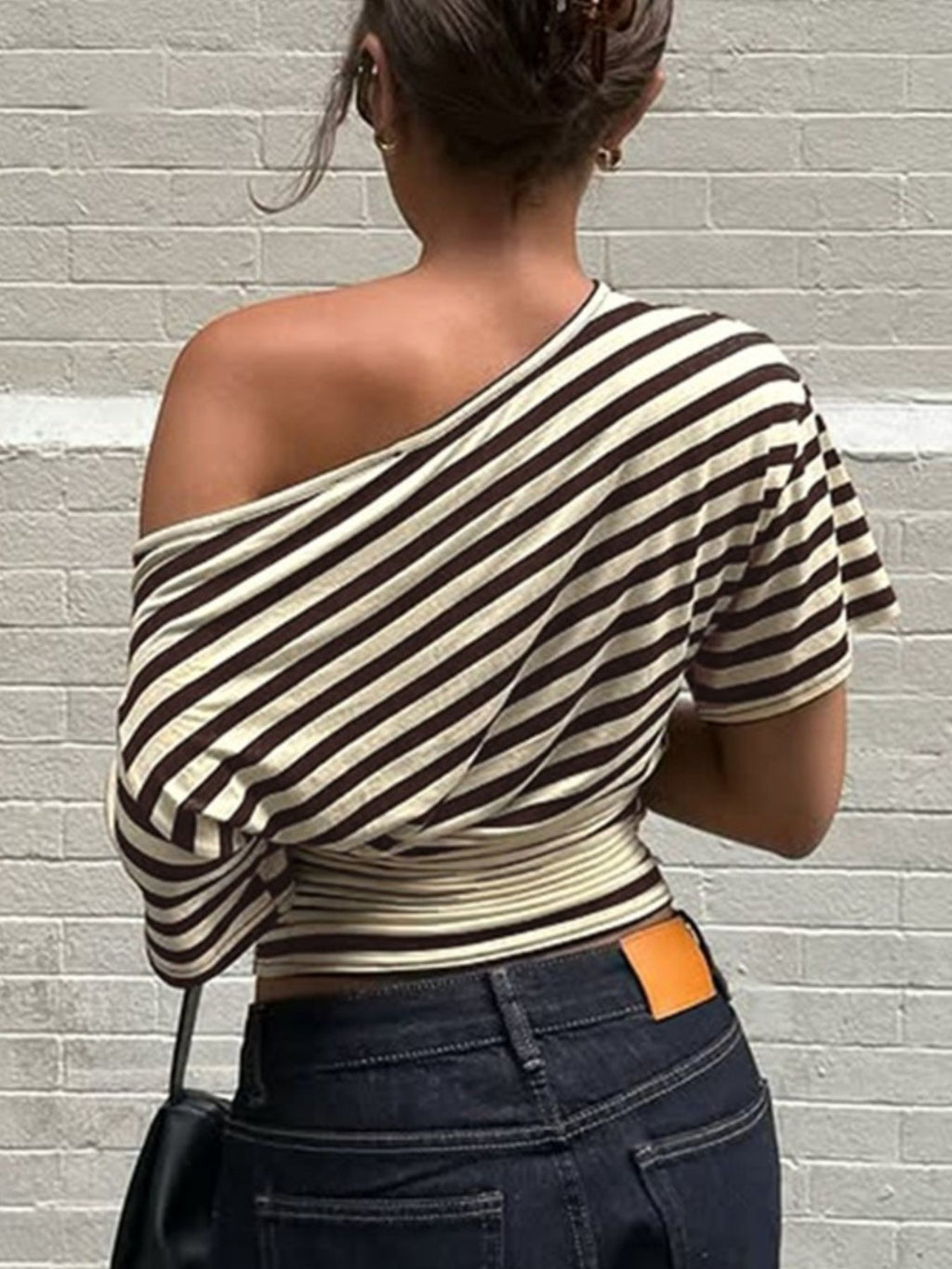 Women's striped one-shoulder T-shirt by Trendsi featuring a chic, asymmetrical design and comfortable fit on a model.