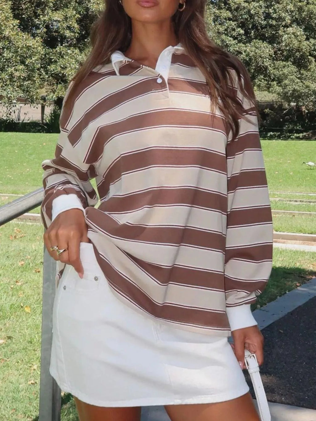 Striped long sleeve polo top with button details from Trendsi, featuring a classic design and comfortable fit.